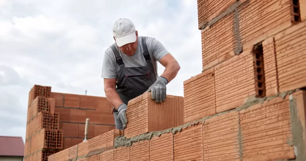 Albanil colocando bloques de termoarcilla en un muro de una vivienda en obra
