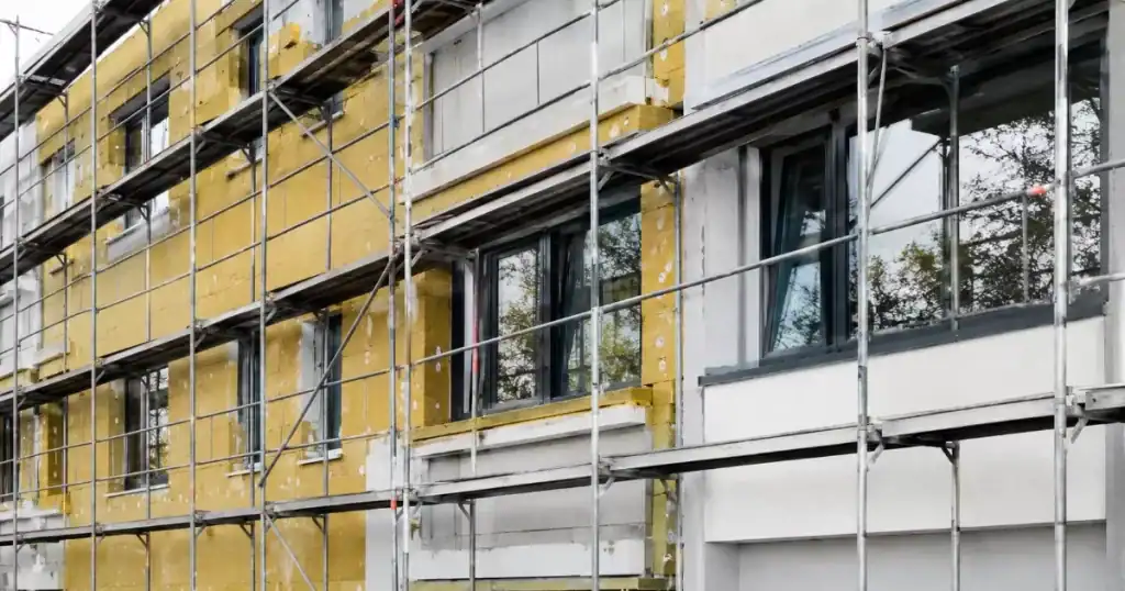 Edificio residencial en rehabilitacion energetica con andamios y nuevo aislamiento termico y ventanas
