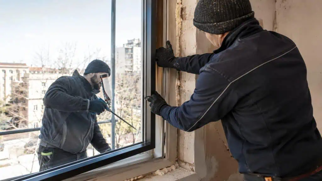 Operarios instalando una ventana nueva de doble acristalamiento sustituyendo la antigua, rehabilitación energética de edificios